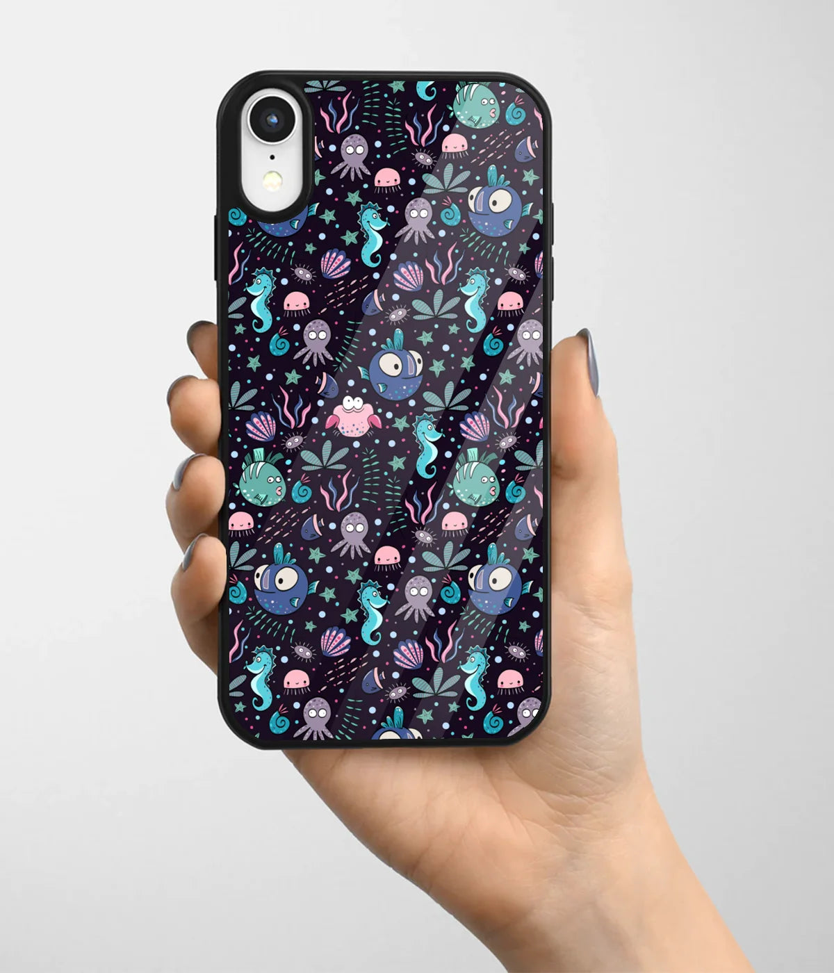 A hand holding a glass phone case with a colorful design.