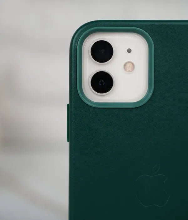 Close-up shot of the premium Cyprus Green leather case for iPhone detailing raised protective lip around the iPhone camera module.
