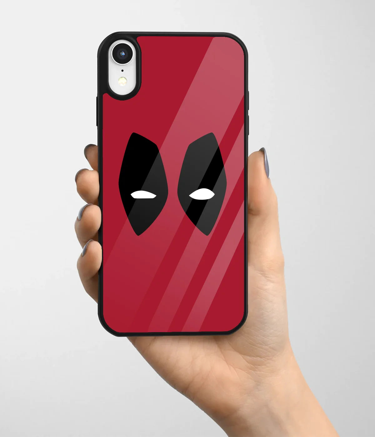 A hand holding a glass phone case with a colorful design.