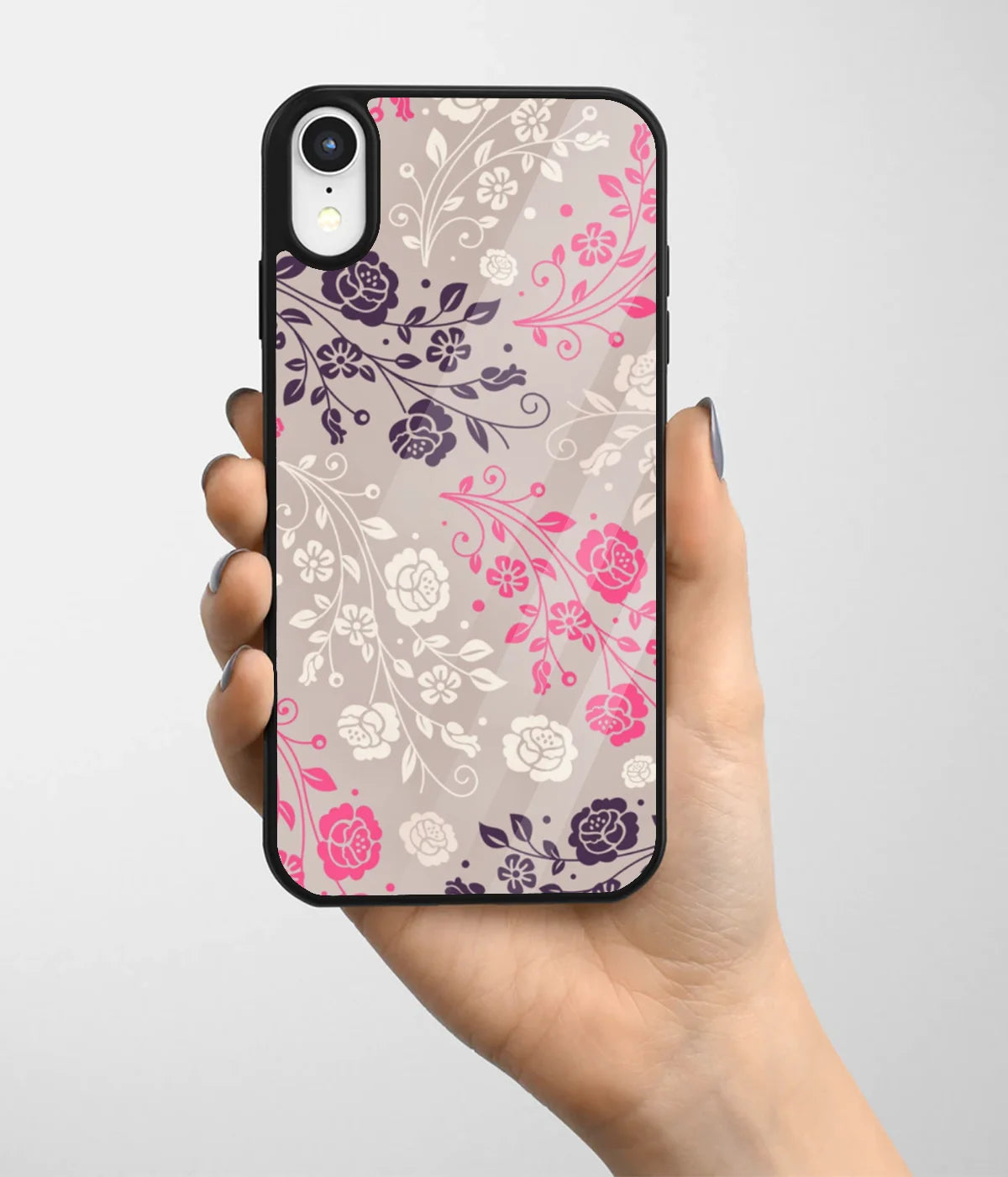 A hand holding a glass phone case with a colorful design.