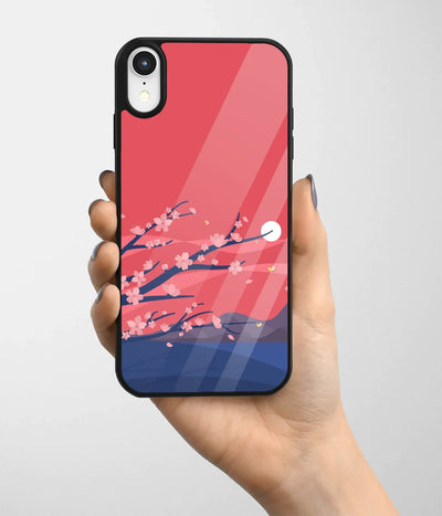 A hand holding a glass phone case with a colorful design.