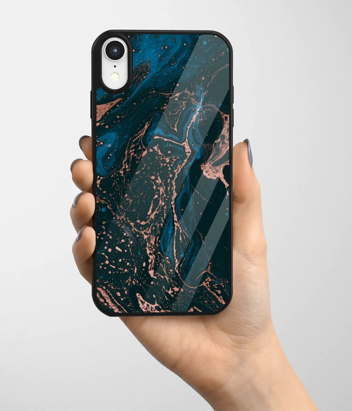 A hand holding a glass phone case with a colorful design.