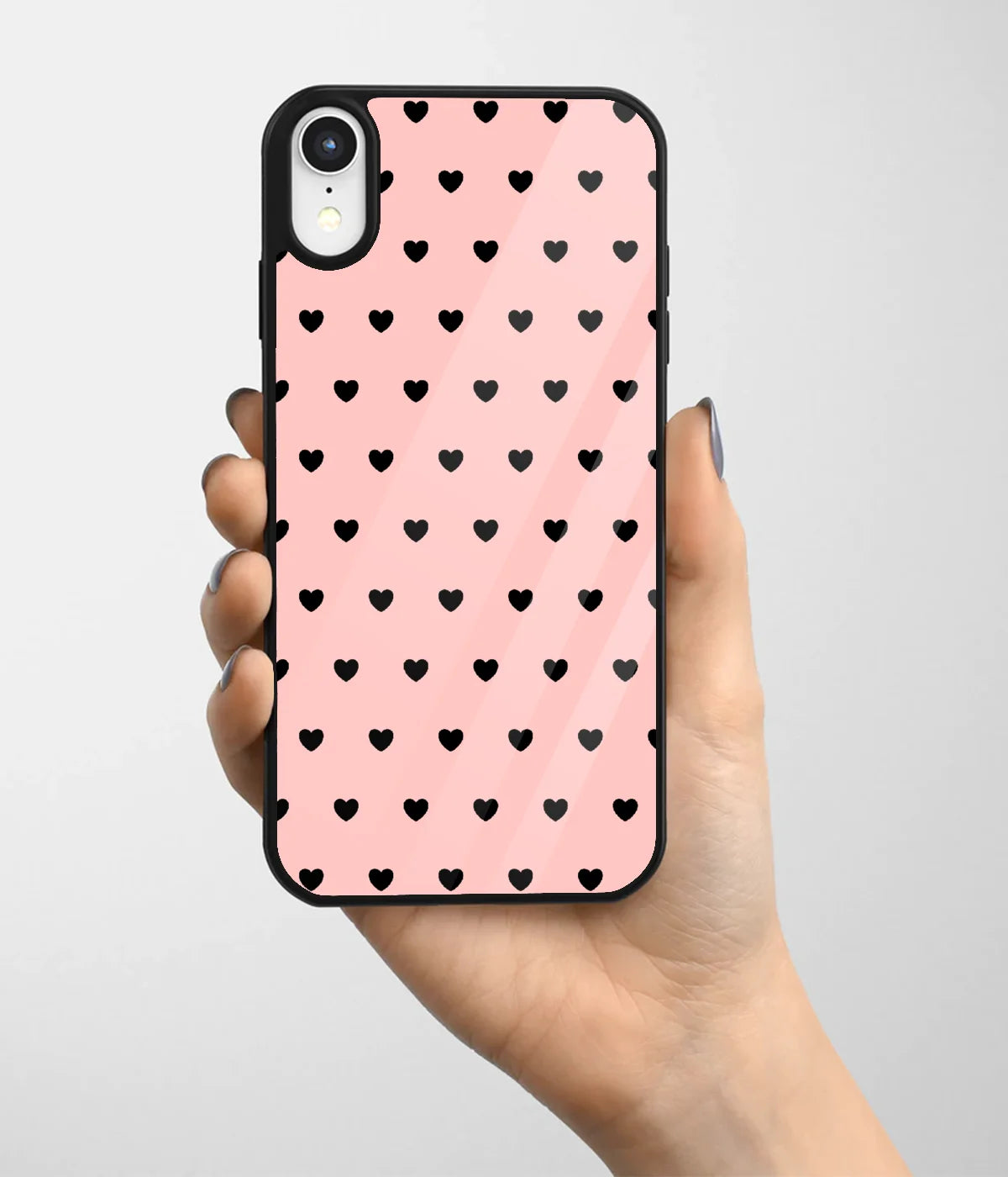 A hand holding a glass phone case with a colorful design.