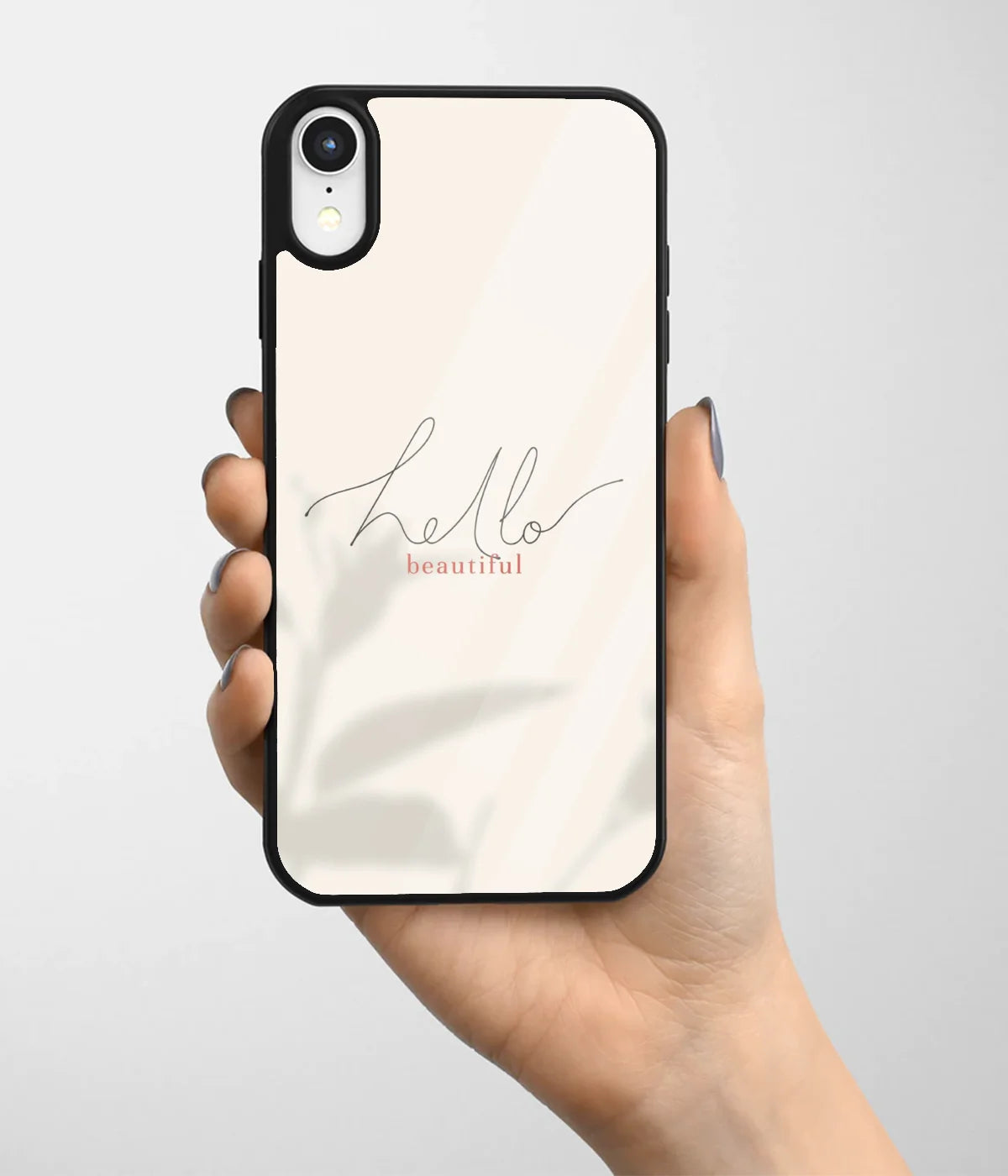 A hand holding a glass phone case with a colorful design.