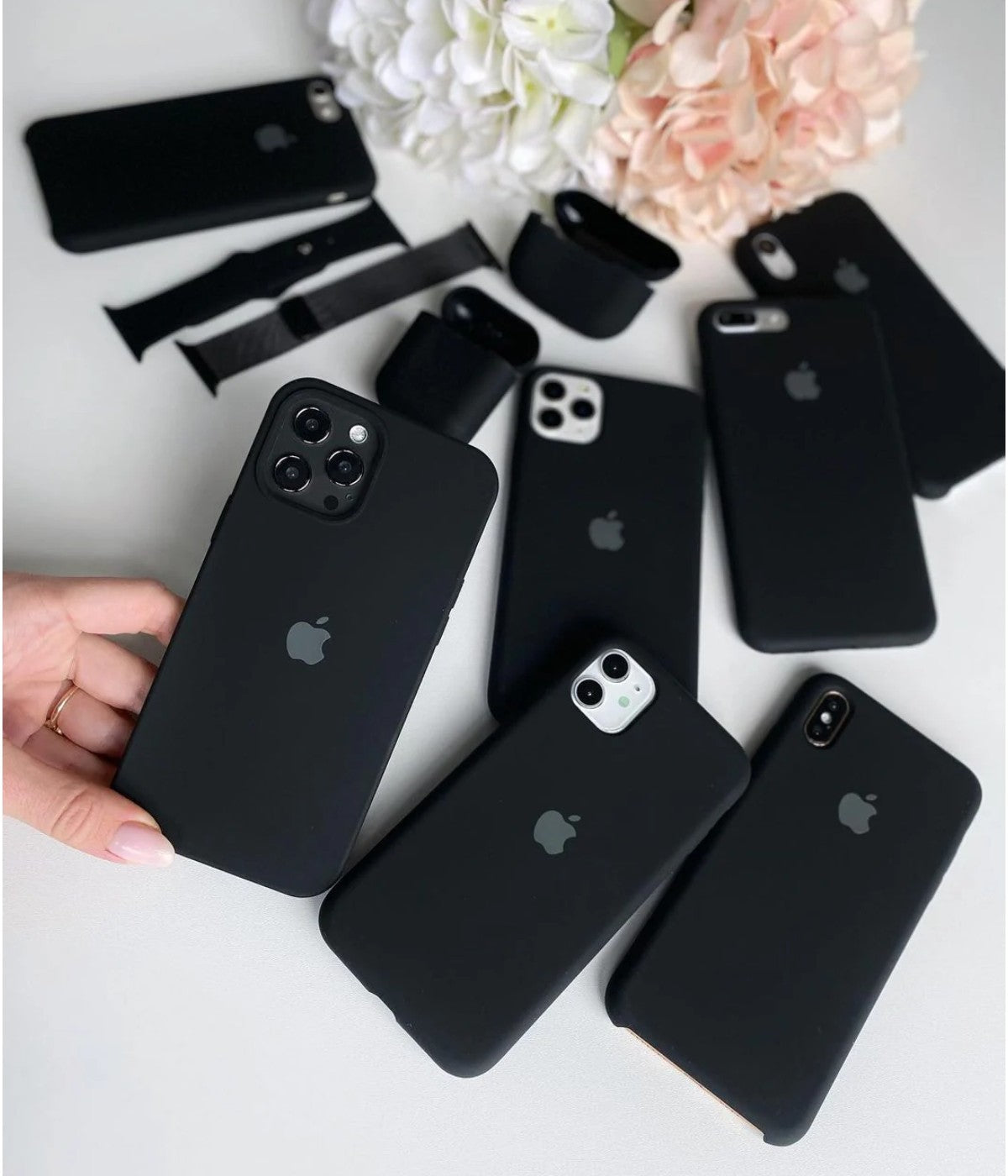  A collection of black silicone iPhone cases and accessories arranged on a white surface.