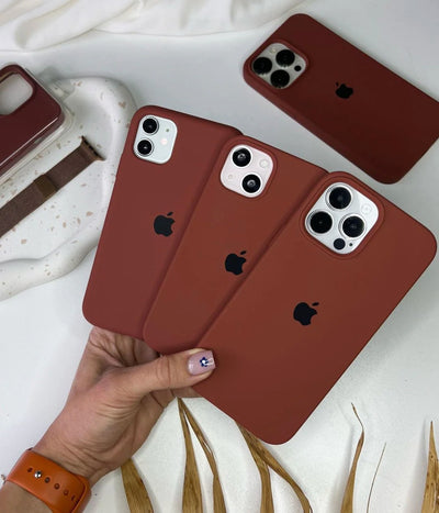 Multiple brown iPhone silicone cases on a white surface.