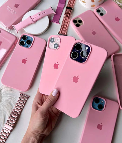 Multiple cameo pink iPhone silicone cases on a white surface.