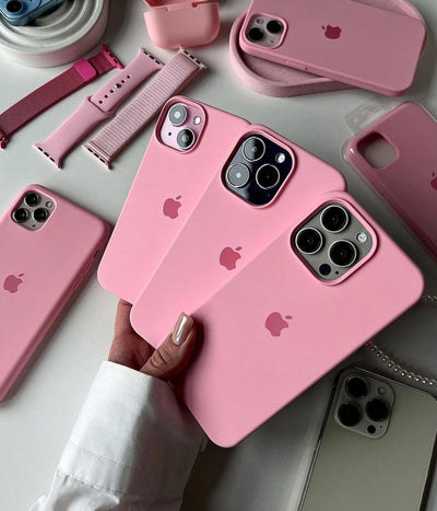 Multiple cameo pink iPhone silicone cases on a white fabric background