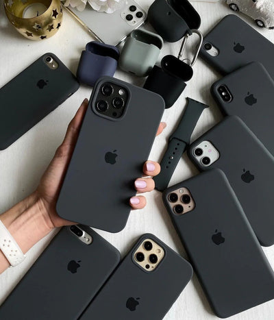 Multiple dark grey iPhone silicone cases on a white surface.