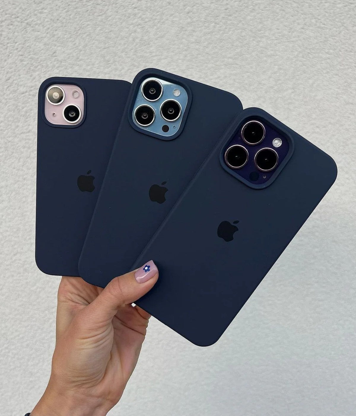 Multiple deep navy iPhone silicone cases on a white surface.