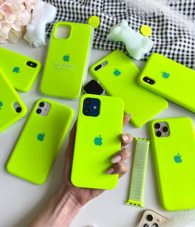 Multiple fluorescent green iPhone silicone cases on a white surface.