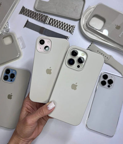 Multiple light grey iPhone silicone cases on a white surface.