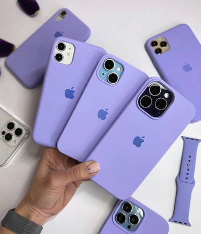 Multiple lilac iPhone silicone cases on a white surface.