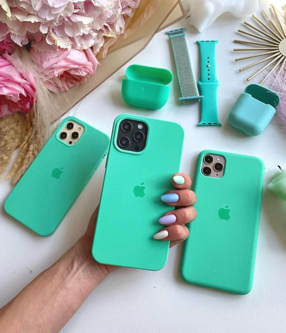 Multiple mint green iPhone silicone cases on a white surface.