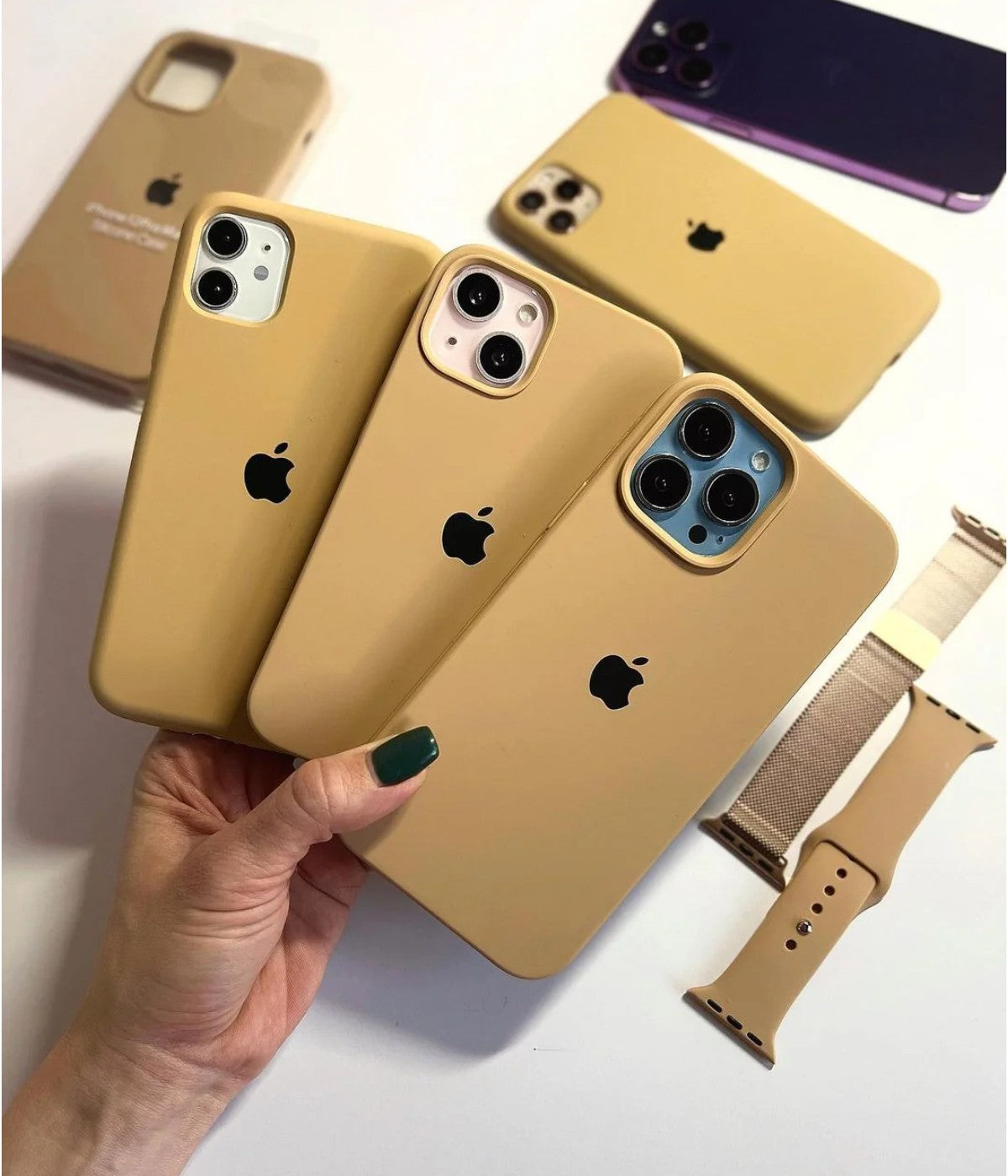 Multiple mustard yellow iPhone silicone cases on a white fabric background