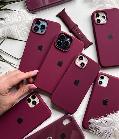 Multiple plum iPhone silicone cases on a white surface.