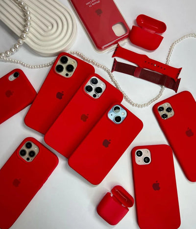 Multiple red iPhone silicone cases on a white surface.