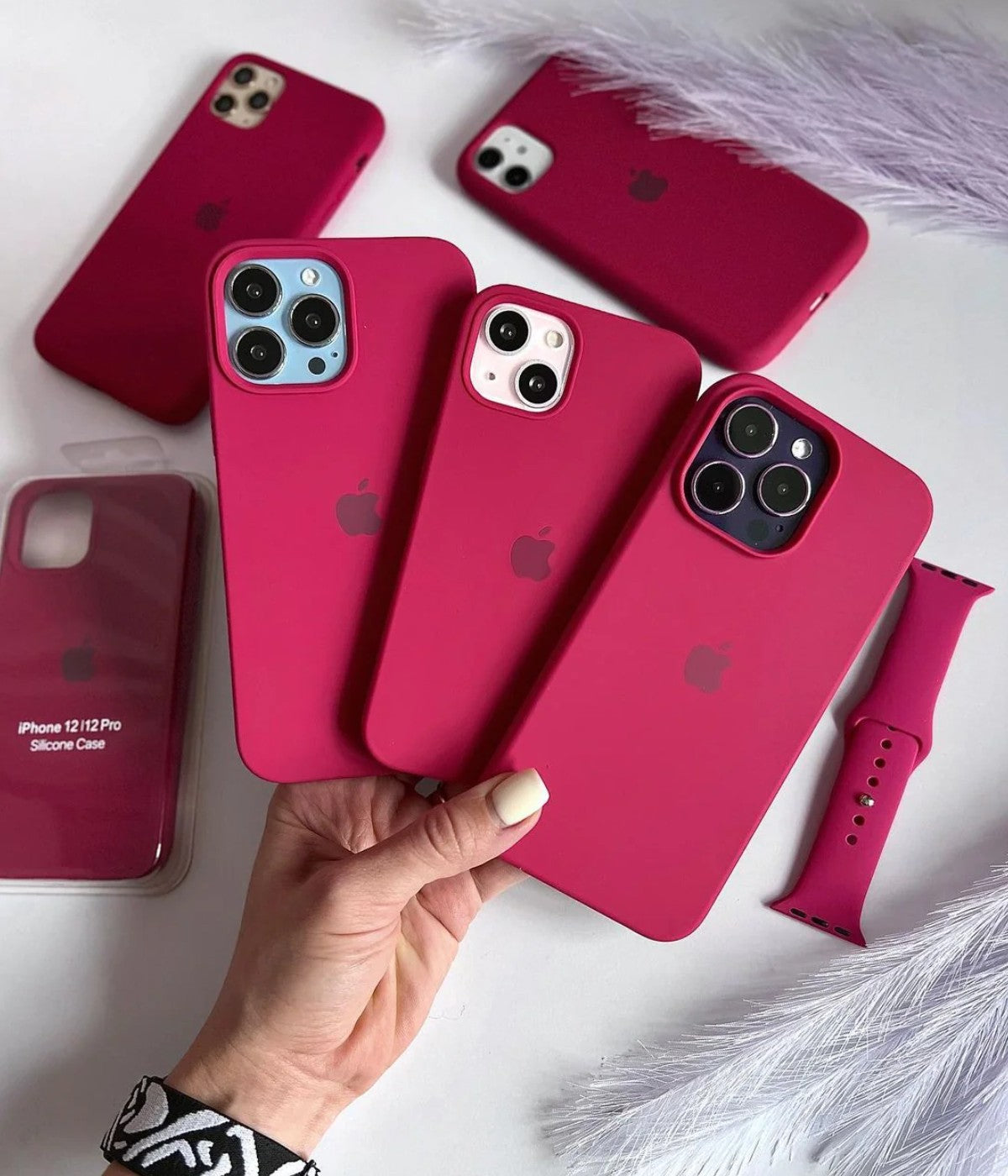 Multiple red rose iPhone silicone cases on a white surface.