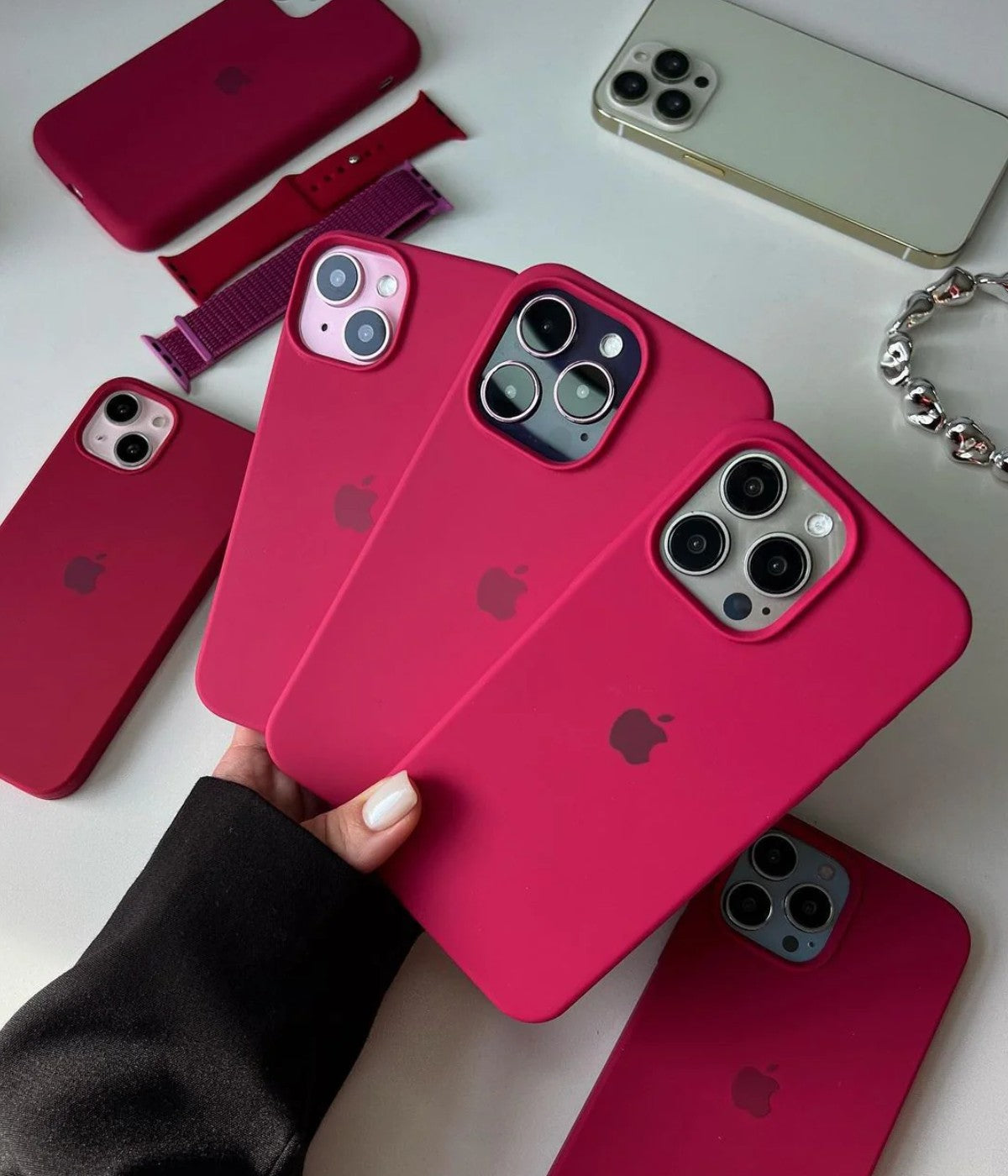 Multiple red rose iPhone silicone cases on a white fabric background