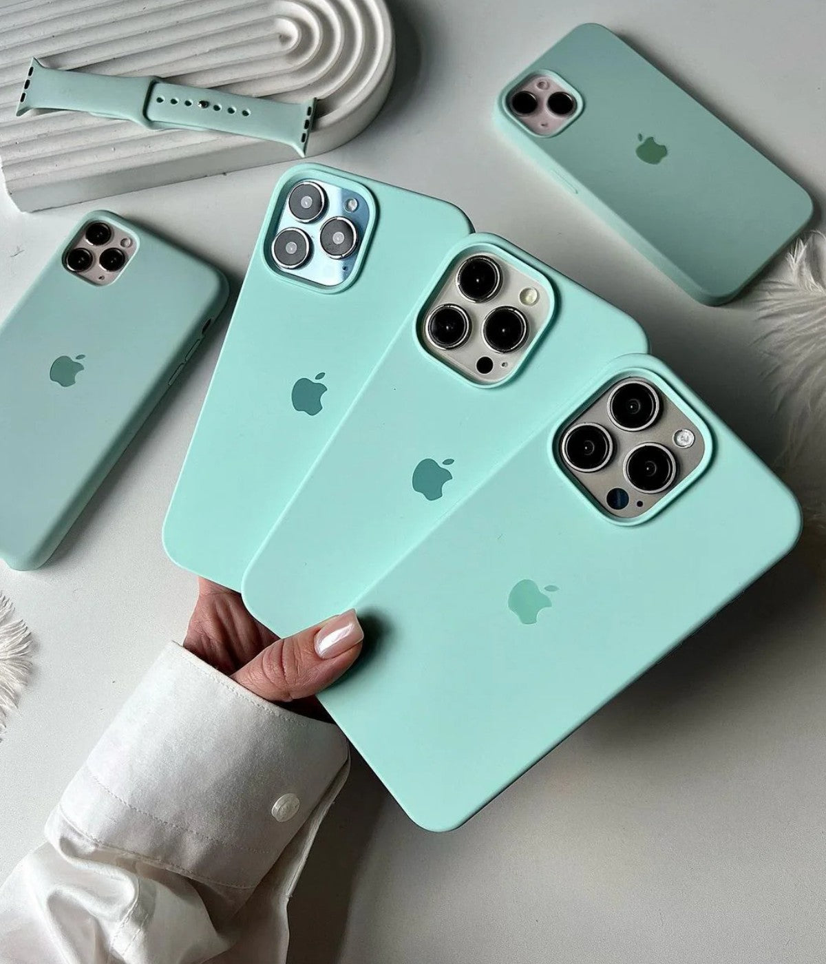 Multiple seafome iPhone silicone cases on a white surface.