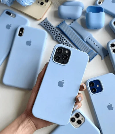 Multiple sky blue iPhone silicone cases on a white fabric background