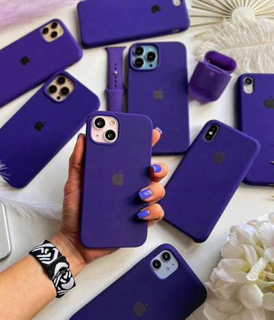 Multiple violet iPhone silicone cases on a white surface.