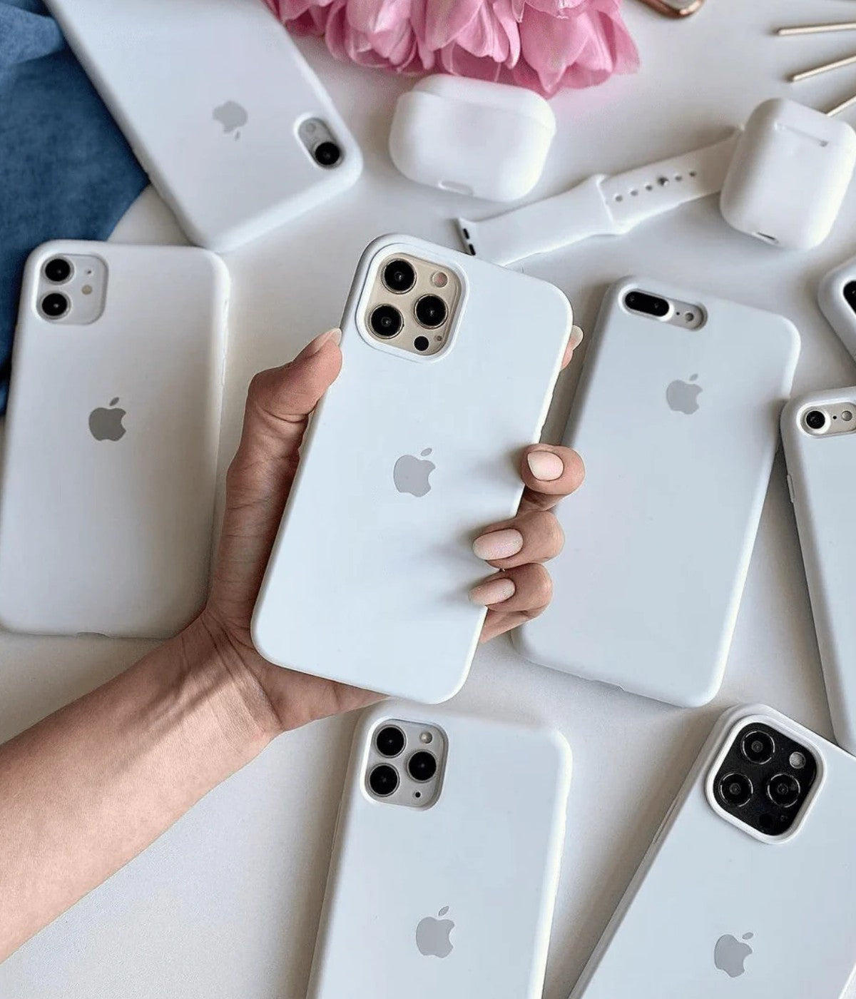 Multiple white iPhone silicone cases on a white surface.