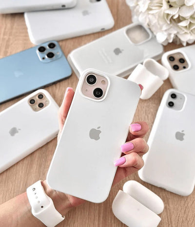 Multiple white iPhone silicone cases on a white fabric background.