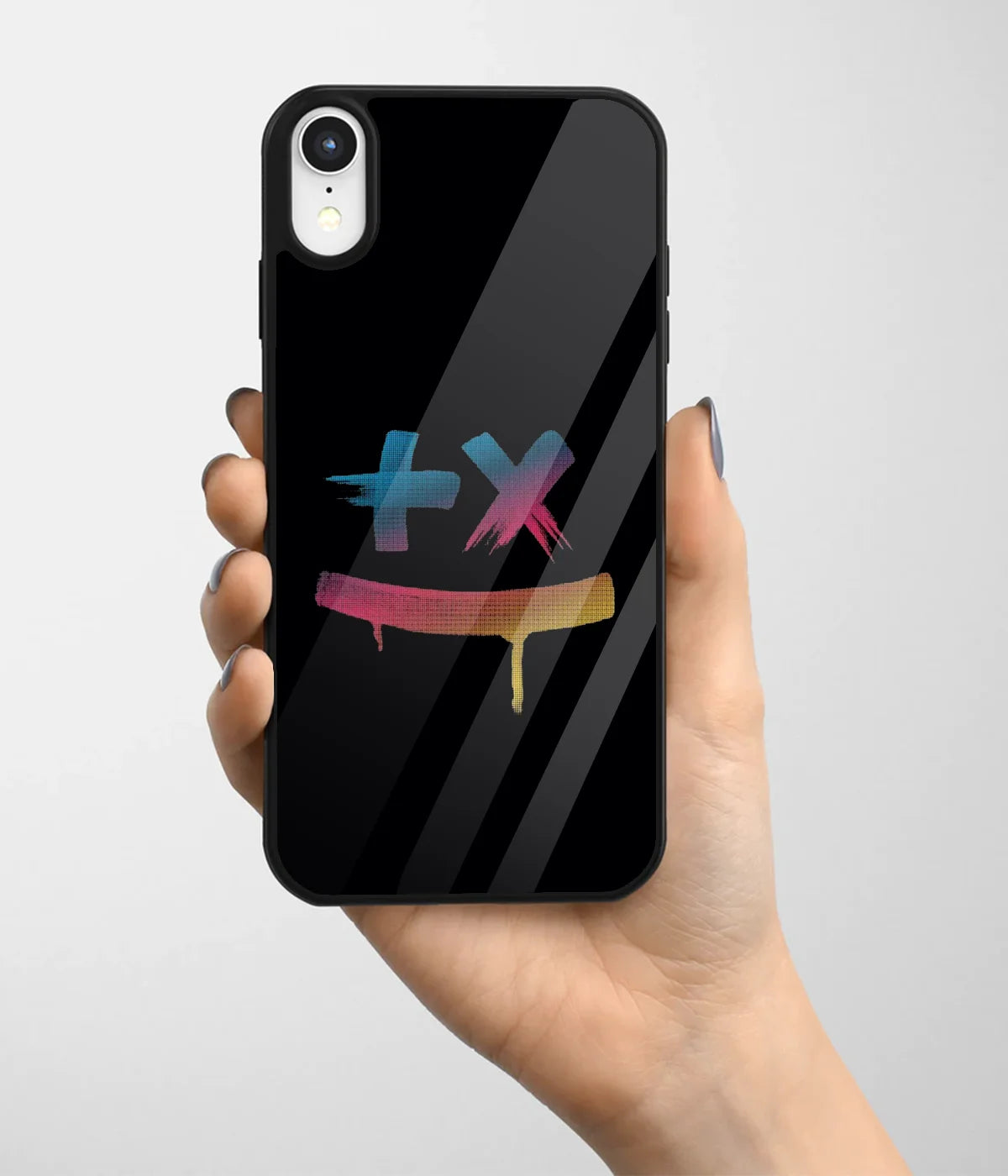 A hand holding a glass phone case with a colorful design.