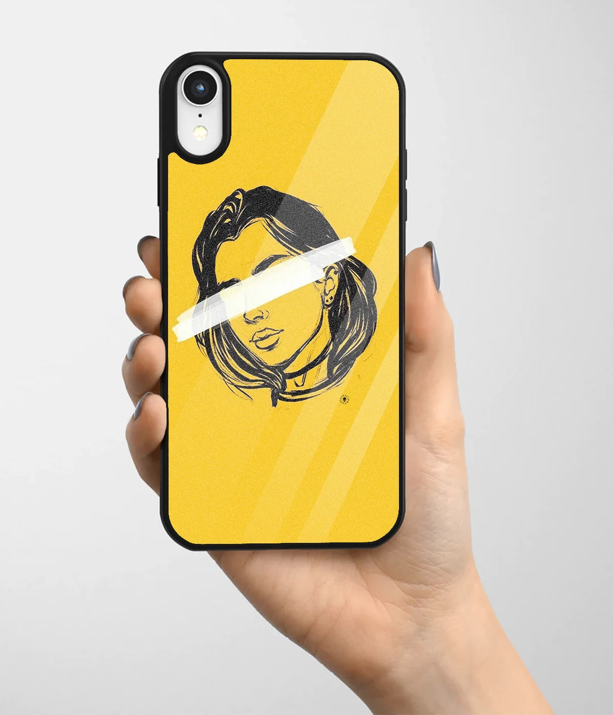 A hand holding a glass phone case with a colorful design.