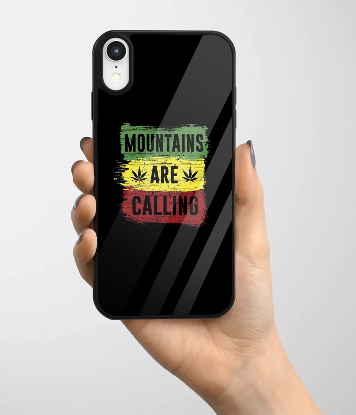 A hand holding a glass phone case with a colorful design.