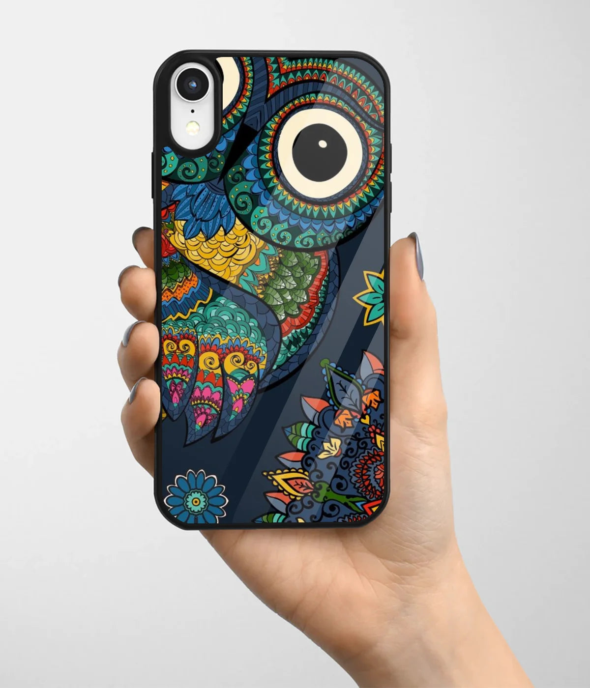 A hand holding a glass phone case with a colorful design.