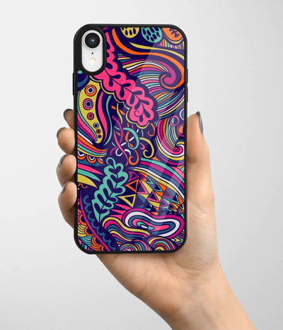 A hand holding a glass phone case with a colorful design.