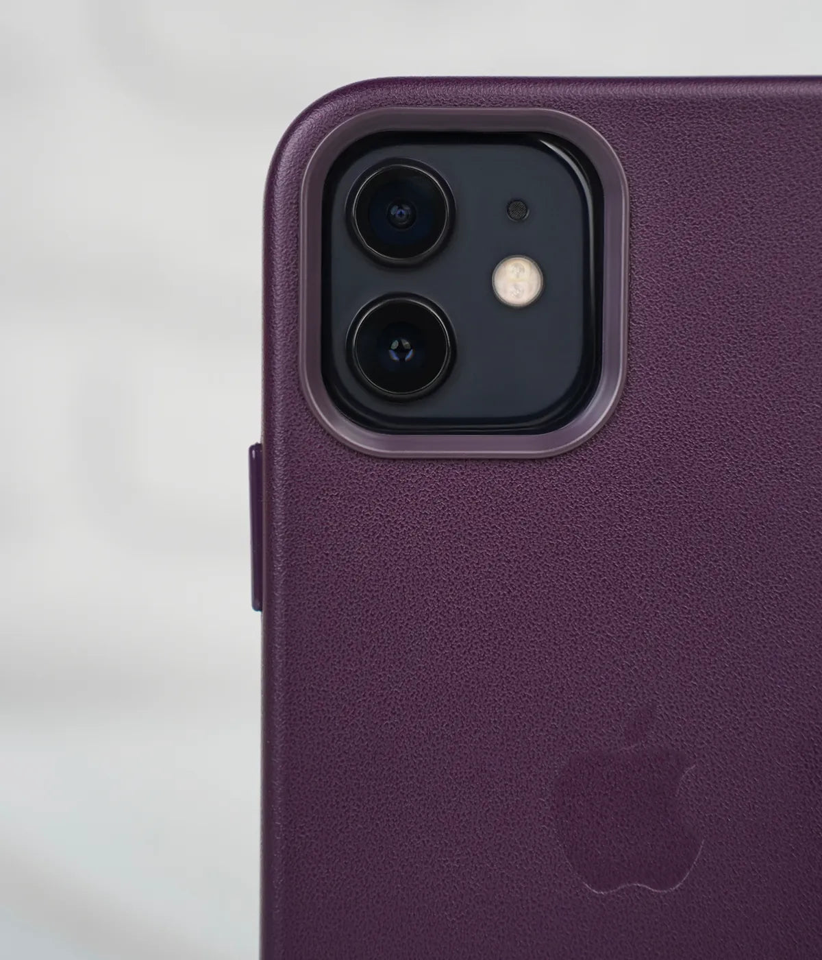 Close-up shot of the premium purple leather case for iPhone detailing raised protective lip around the iPhone camera module.
