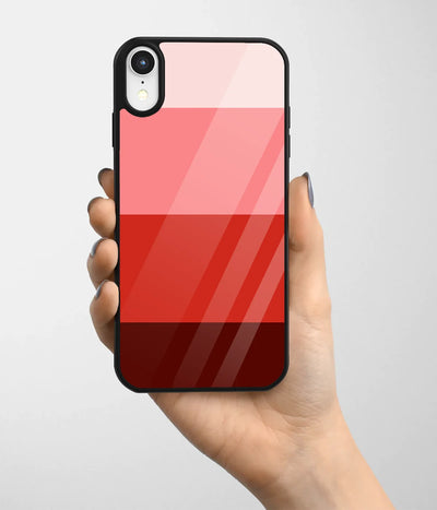 A hand holding a glass phone case with a colorful design.