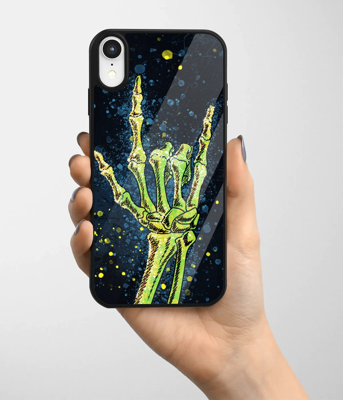 A hand holding a glass phone case with a colorful design.