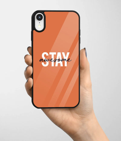 A hand holding a glass phone case with a colorful design.