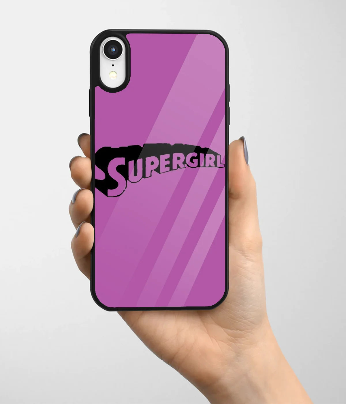 A hand holding a glass phone case with a colorful design.