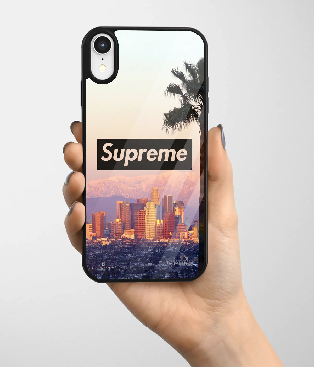 A hand holding a glass phone case with a colorful design.