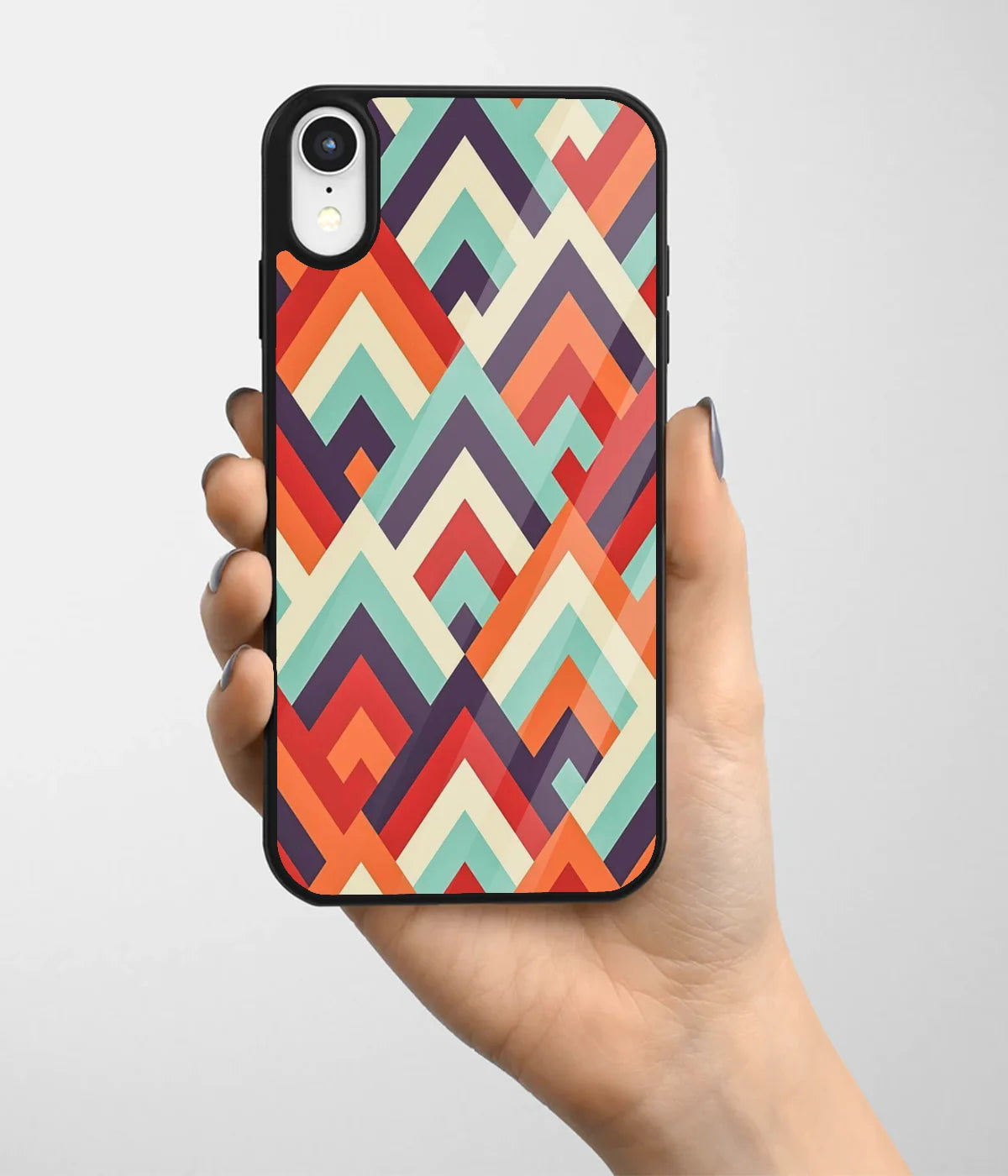 A hand holding a glass phone case with a colorful design.
